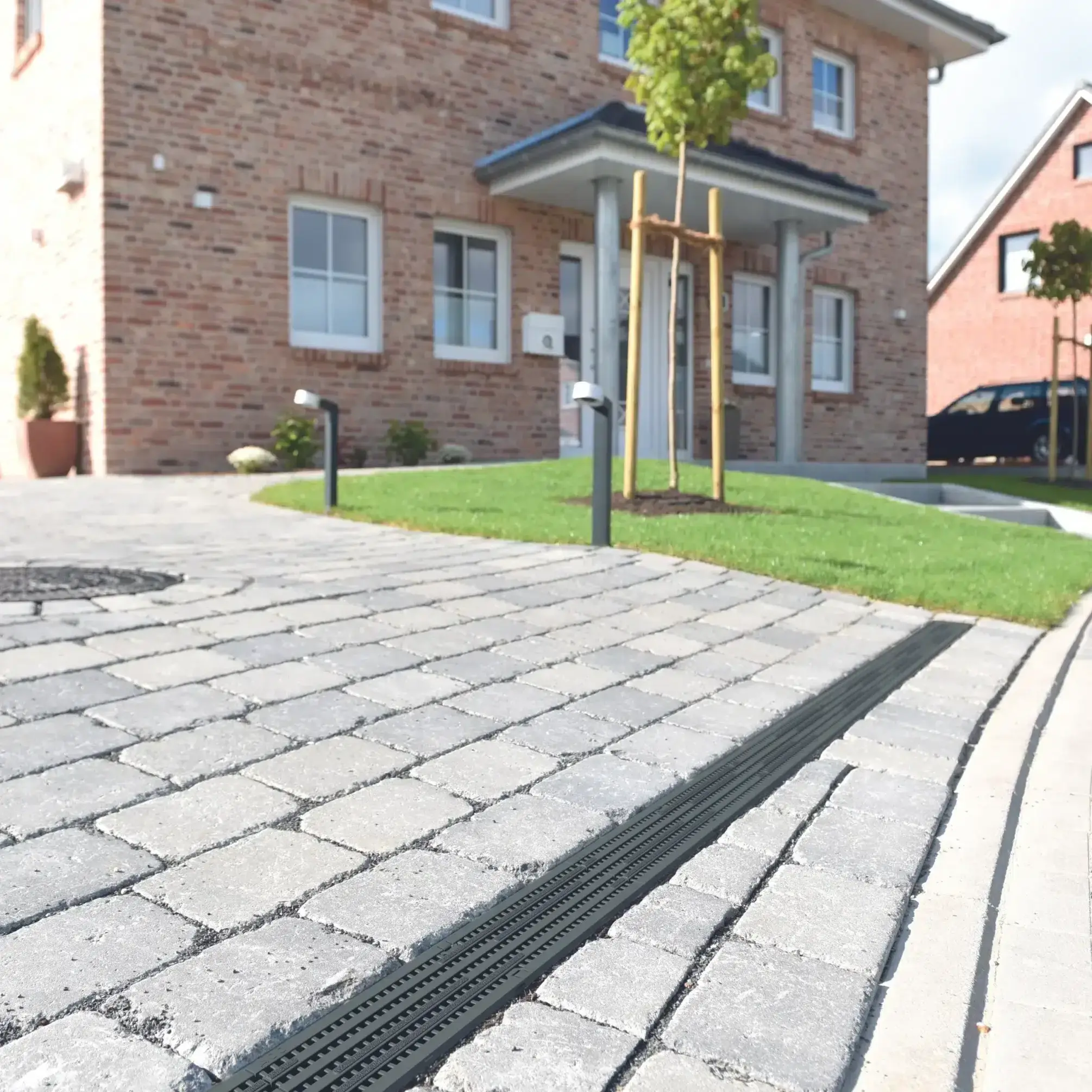 Aco caniveau self grid entre des pavés